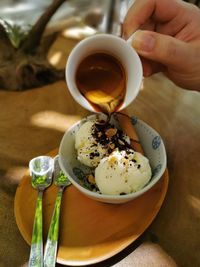 Close-up of hand holding tea cup on table