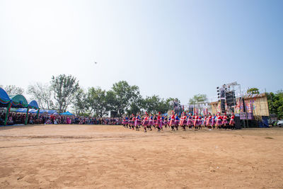 Group of people in park against clear sky