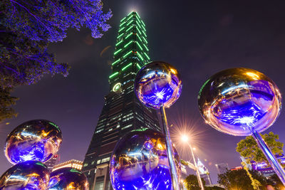 Low angle view of illuminated buildings against sky at night