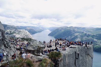 Group of people on mountain against sky