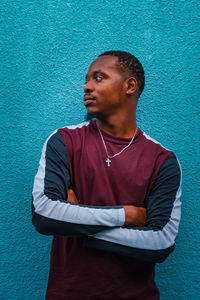 Portrait of young man standing against wall