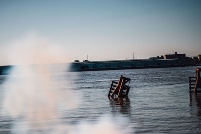 Boats in calm sea at sunset