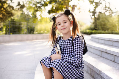 Portrait of young kid girl holding boks wear checkered dressoutdoor