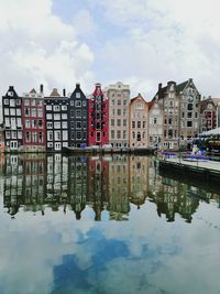 Reflection of buildings in canal against sky