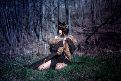 Rear view of woman standing in forest