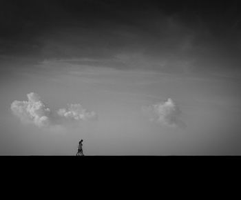 Silhouette person standing on field against sky