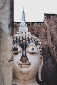 Close-up of buddha statue against building