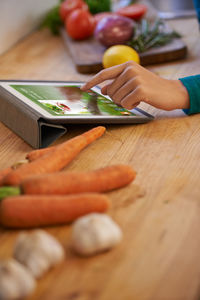 Cropped hand of woman holding food on table