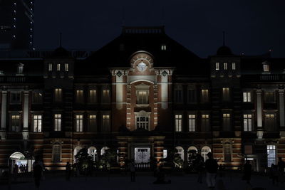 People in illuminated building at night