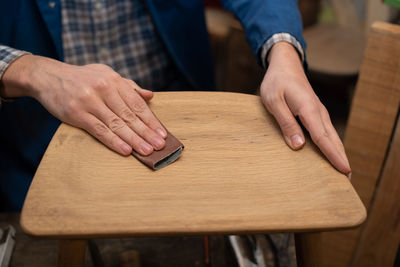 Midsection of man holding umbrella on table