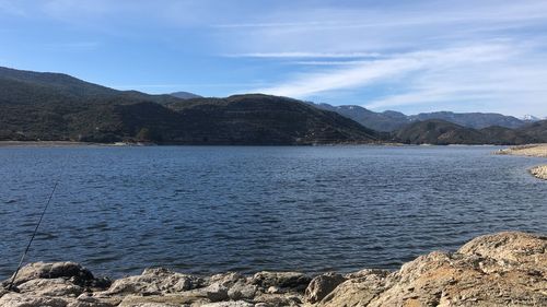 Scenic view of lake by mountains against sky