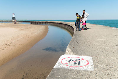 People on beach against clear sky