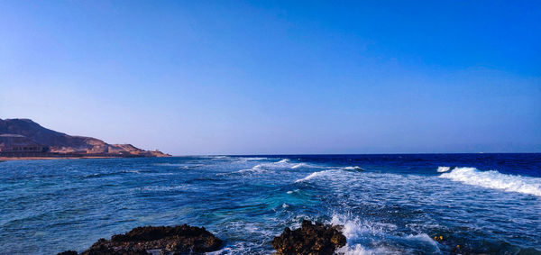 Scenic view of sea against clear blue sky