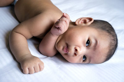 Close-up of baby boy lying on bed