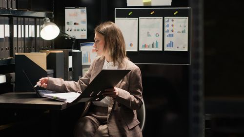 Rear view of woman using mobile phone in office