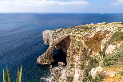 Scenic view of rock formation in sea against sky