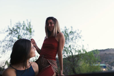 Lesbian couple against clear sky