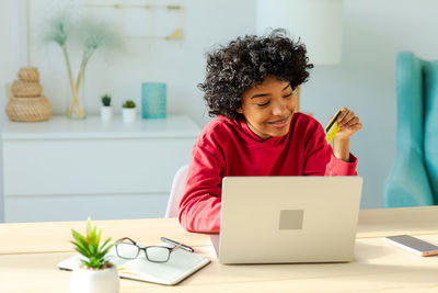 Young woman using laptop at table