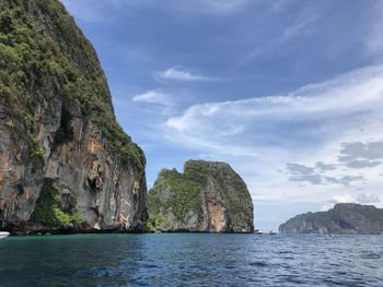 Rock formations by sea against sky