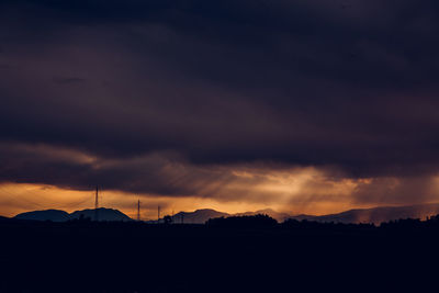 Silhouette of windmill against sky at sunset