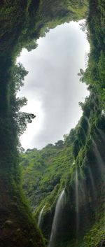 Scenic view of waterfall against sky