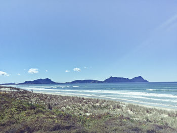 Scenic view of beach against blue sky