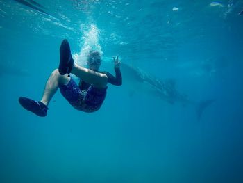 Man gesturing peace sign while snorkeling in sea