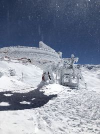 People on snow covered field against sky