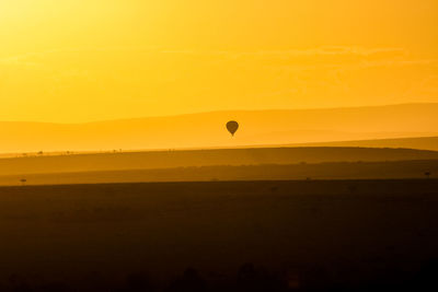 Silhouette hot air balloon against sky during sunset