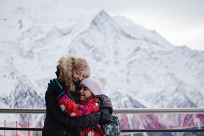 Side view of woman looking at snowcapped mountain