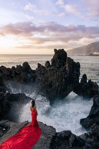 Scenic view of rocks on beach against sky during sunset