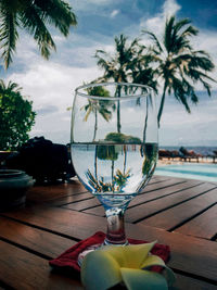 Close-up of wine glass on table against sky