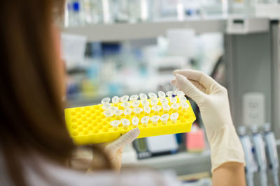 Cropped image of scientist holding vial rack at lab