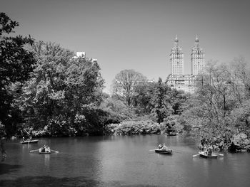 Scenic view of river by buildings against clear sky