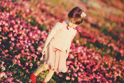 Midsection of woman on flowering plant at field