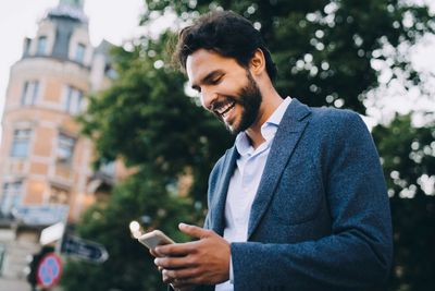 Side view of young man using mobile phone