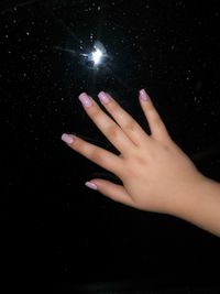 Close-up of human hand against black background