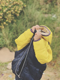 Person removing jacket while standing on land