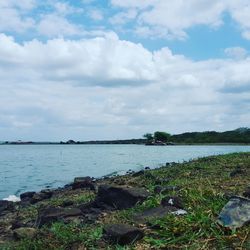 Scenic view of calm lake against cloudy sky