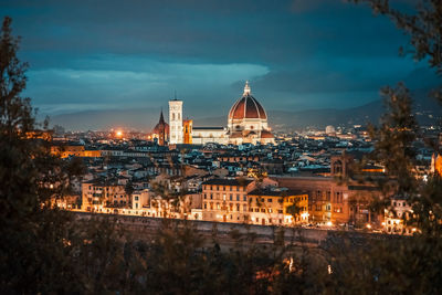 High angle view of city lit up against sky