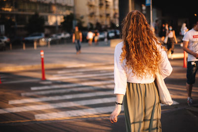 Rear view of woman walking on street in city