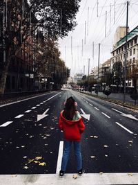 Woman standing on road in city