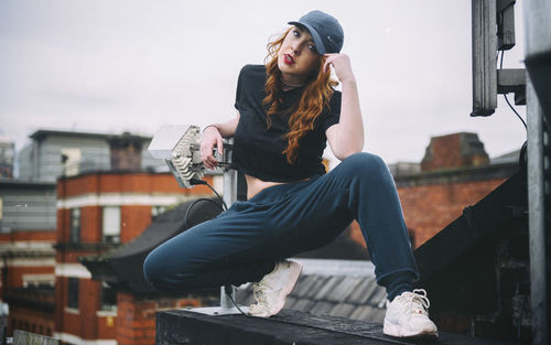 Young woman looking away while sitting outdoors