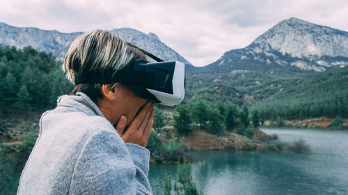 Side view of man wearing hat by lake