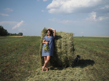 Rear view of woman standing on field against sky