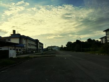 Empty road against cloudy sky