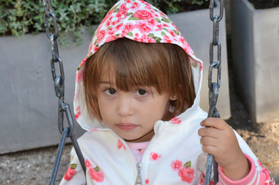 Portrait of boy swinging at playground