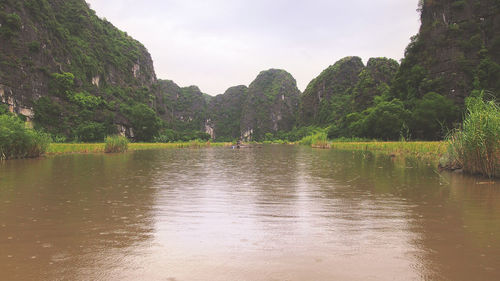 Scenic view of lake by trees against sky