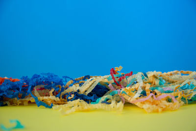 Close-up of multi colored candies against blue background