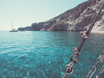 Sailboats in sea against clear sky